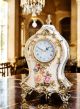 Orologio da tavolo in ceramica raffinata, con eleganti dettagli floreali e dorati, realizzato artigianalmente.