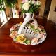 Centrotavola, cesto in ceramica arricchito da fiori e raffinati dettagli dorati, realizzato a mano.