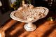Alzata in ceramica di elevato prestigio, decorata con rose, cristalli e rifiniture dorate.