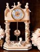 Orologio a pendolo con colonne e amorini, ceramica di elevato prestigio, fatto a mano.